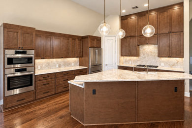 Large trendy kitchen photo in Houston with a double-bowl sink, shaker cabinets, medium tone wood cabinets, quartzite countertops, quartz backsplash, stainless steel appliances, an island and beige countertops