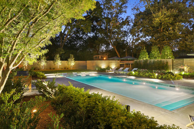 Example of a mid-sized minimalist backyard concrete and rectangular pool design in New Orleans