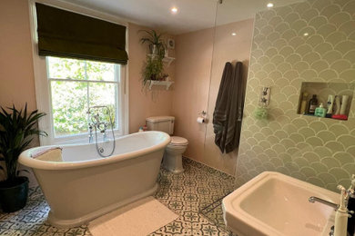 Traditional family bathroom with a freestanding bath, a walk-in shower, a one-piece toilet, green tiles, ceramic tiles, pink walls, ceramic flooring, a built-in sink, green floors, an open shower, a wall niche, a single sink and a built in vanity unit.
