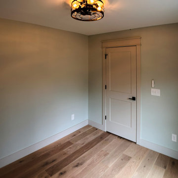 Cozy Modern Farmhouse Office: Light Oak Floors, Soft Green Walls, and Warm Light