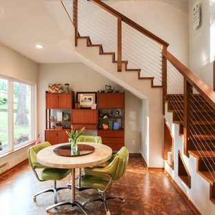 50 tals inredning av en mellanstor matplats med öppen planlösning, med grå väggar och korkgolv