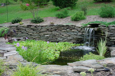 Photo of a large transitional full sun backyard stone landscaping in DC Metro for spring.
