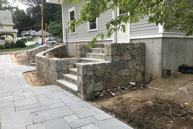 BLUESTONE PATIO AND WALKWAY WITH STONE WALLS AND GRANITE STEPS