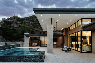 Large contemporary beige one-story stucco exterior home idea in Phoenix with a metal roof and a black roof