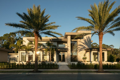 Inspiration for a large modern two-storey stucco house exterior in Orlando with a flat roof.