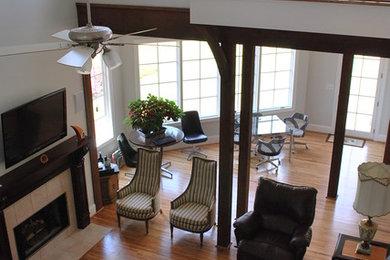 Family room - large transitional open concept light wood floor and brown floor family room idea in Birmingham with a standard fireplace, a tile fireplace, white walls and a wall-mounted tv