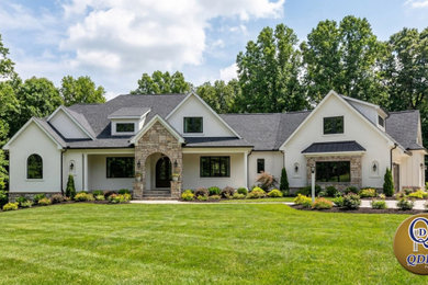 Example of a minimalist white two-story stucco and board and batten exterior home design in Other with a mixed material roof and a gray roof