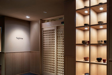 Diseño de hall asiático con moqueta, puerta corredera y puerta de madera clara