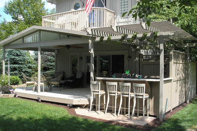 Example of a mid-sized classic backyard outdoor kitchen deck design in Grand Rapids with a roof extension
