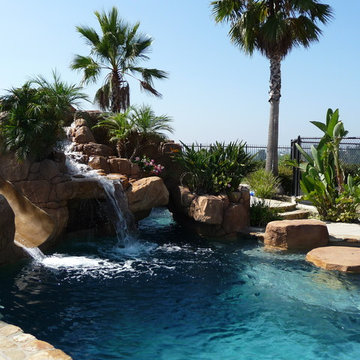 Rock Swimming Pool with Slide, Waterfall and a Table in the pool.