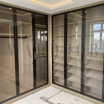 Bespoke dressing room with Italian brown tinted glass doors and the island