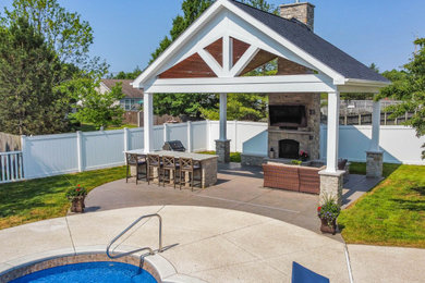 Inspiration for a large backyard stamped concrete patio remodel in St Louis with a fireplace and a gazebo