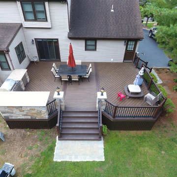 Mix of the modern synthetic decking with rustic veneer stone kitchen,