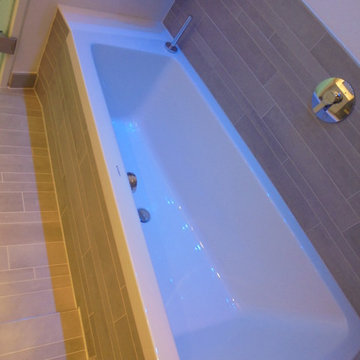 Die weiße Wanne und die grauen Riemchen-Fliesen durch das LED-Farblicht getönt