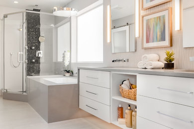This is an example of a large contemporary master bathroom in Seattle with flat-panel cabinets, white cabinets, an undermount tub, a corner shower, black and white tile, porcelain floors, an undermount sink, solid surface benchtops, grey floor, a hinged shower door and grey benchtops.