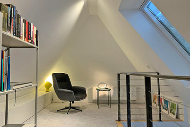 Kleine, Offene Moderne Bibliothek mit weißer Wandfarbe, Teppichboden und grauem Boden in Sonstige