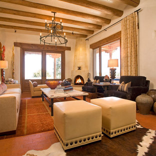 Repräsentatives, Fernseherloses, Großes, Offenes Mediterranes Wohnzimmer mit beiger Wandfarbe, Backsteinboden und Eckkamin in Albuquerque