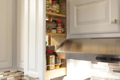 Inspiration for a mid-sized contemporary u-shaped slate floor enclosed kitchen remodel in San Francisco with an undermount sink, raised-panel cabinets, white cabinets, soapstone countertops, metallic backsplash, mosaic tile backsplash, white appliances and no island
