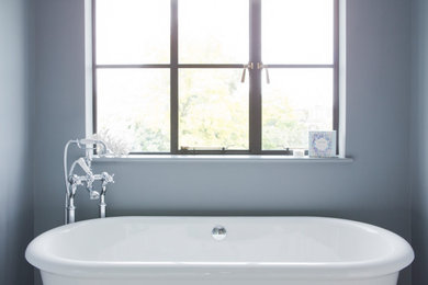 Freestanding bathtub - mid-sized traditional master freestanding bathtub idea in London with gray walls