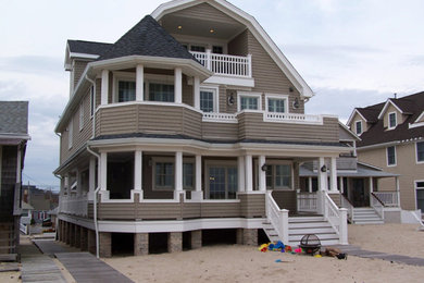 Inspiration for a large coastal beige three-story wood house exterior remodel in Other with a gambrel roof and a shingle roof