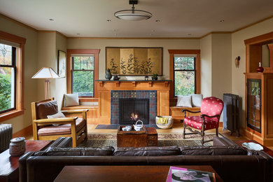 シアトルにあるトラディショナルスタイルのおしゃれなリビング (淡色無垢フローリング、タイルの暖炉まわり、茶色い床) の写真