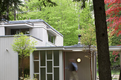 Inspiration for a 1950s gray two-story flat roof remodel in Boston
