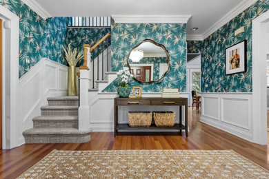 Entryway - modern medium tone wood floor, brown floor and wallpaper entryway idea in New York with a dark wood front door