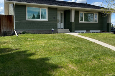 Mid-sized transitional green one-story concrete fiberboard and shingle house exterior photo in Calgary