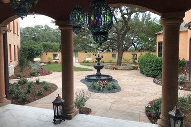 Photo of a large mediterranean courtyard stone landscaping in Other.