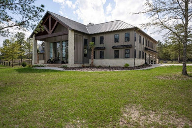 Example of a huge cottage gray two-story concrete fiberboard and board and batten exterior home design in Other with a metal roof and a gray roof