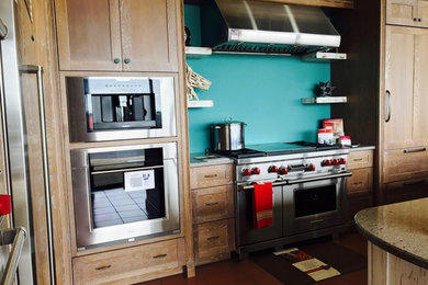 Eat-in kitchen - contemporary eat-in kitchen idea in Charlotte with granite countertops, blue backsplash, stainless steel appliances and an island