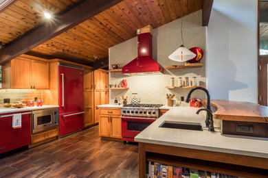 Example of a mid-sized eclectic u-shaped porcelain tile and brown floor eat-in kitchen design in Philadelphia with a farmhouse sink, shaker cabinets, medium tone wood cabinets, quartz countertops, beige backsplash, porcelain backsplash, colored appliances, a peninsula and beige countertops