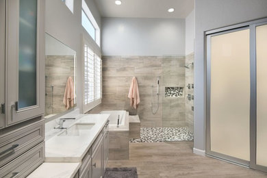 Inspiration for a transitional master bathroom in Phoenix with beaded inset cabinets, grey cabinets, a drop-in tub, a curbless shower, beige tile, ceramic tile, grey walls, ceramic floors, an undermount sink, marble benchtops, beige floor and an open shower.