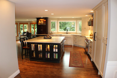 Eat-in kitchen - large traditional medium tone wood floor eat-in kitchen idea in Seattle with a farmhouse sink, recessed-panel cabinets, distressed cabinets, quartzite countertops, beige backsplash, ceramic backsplash, stainless steel appliances, an island and beige countertops