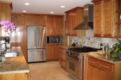 Mid-sized trendy u-shaped ceramic tile and beige floor enclosed kitchen photo in San Francisco with a double-bowl sink, shaker cabinets, medium tone wood cabinets, granite countertops, gray backsplash, stone tile backsplash, stainless steel appliances and no island