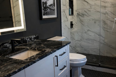 Mid-sized minimalist 3/4 black and white tile and porcelain tile porcelain tile, black floor and single-sink bathroom photo in Philadelphia with shaker cabinets, white cabinets, a one-piece toilet, gray walls, a drop-in sink, marble countertops, black countertops, a niche and a freestanding vanity
