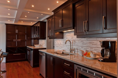 This is an example of a mid-sized contemporary l-shaped open plan kitchen in Vancouver with shaker cabinets, dark wood cabinets, beige splashback, matchstick tile splashback, stainless steel appliances, dark hardwood floors, with island, a double-bowl sink and granite benchtops.