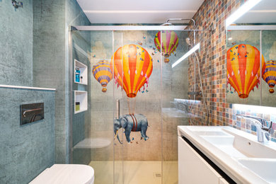 Diseño de cuarto de baño infantil y doble actual de tamaño medio con baldosas y/o azulejos multicolor, baldosas y/o azulejos en mosaico, suelo de baldosas de porcelana, suelo beige, ducha con puerta corredera, armarios con paneles lisos, puertas de armario blancas, ducha empotrada, sanitario de pared, lavabo integrado, encimeras blancas y hornacina