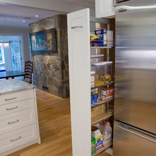 Inspiration för ett mellanstort vintage grå grått kök, med en undermonterad diskho, luckor med infälld panel, vita skåp, bänkskiva i kvartsit, vitt stänkskydd, stänkskydd i tunnelbanekakel, rostfria vitvaror, mellanmörkt trägolv och en köksö