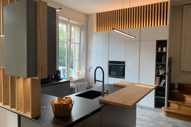 Idée de décoration pour une cuisine ouverte grise et noire minimaliste en U de taille moyenne avec un évier encastré, carreaux de ciment au sol, aucun îlot et un sol gris.