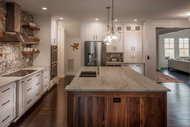 Kitchen - large traditional l-shaped dark wood floor and brown floor kitchen idea in Atlanta with an undermount sink, flat-panel cabinets, white cabinets, quartzite countertops, gray backsplash, ceramic backsplash, stainless steel appliances and an island