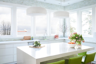 Example of a trendy l-shaped kitchen design in Vancouver with an undermount sink, flat-panel cabinets, white cabinets, stainless steel appliances, an island and white countertops