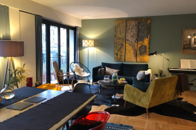 Imagen de salón abierto bohemio de tamaño medio con paredes verdes, suelo de madera clara y suelo beige