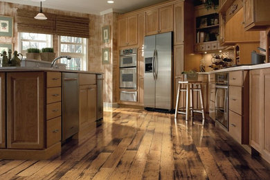 Inspiration for a large rustic l-shaped dark wood floor and brown floor eat-in kitchen remodel in Other with raised-panel cabinets, light wood cabinets, solid surface countertops, stainless steel appliances and an island