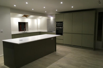 This is an example of a contemporary l-shaped open plan kitchen in Other with a built-in sink, grey cabinets, composite countertops, white splashback, coloured appliances, ceramic flooring, an island, brown floors and white worktops.