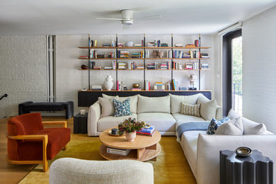 Foto de sala de estar abierta ecléctica con paredes blancas, suelo de madera en tonos medios, suelo marrón y ladrillo