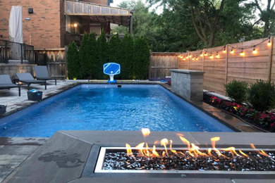 Inspiration for a mid-sized backyard concrete paver and rectangular infinity pool landscaping remodel in Toronto