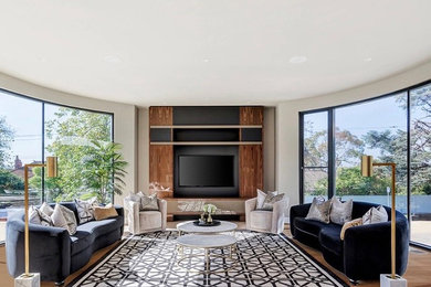 Expansive modern formal open concept living room in Melbourne with grey walls, medium hardwood floors, a built-in media wall and brown floor.