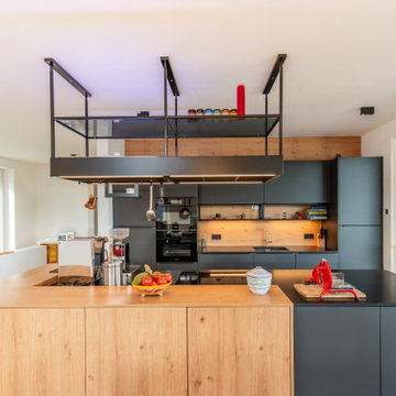 Moderne Küche mit dunklen Fronten und Holz