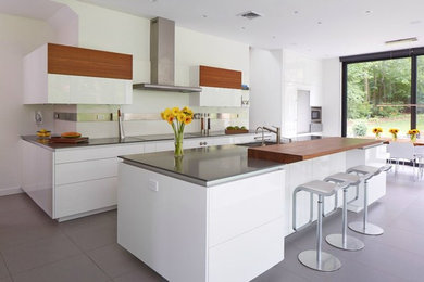 Photo of a mid-sized modern eat-in kitchen in New York with a single-bowl sink, flat-panel cabinets, white cabinets, solid surface benchtops, concrete floors, with island and grey floor.